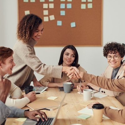 People in a meeting at a table shaking hands